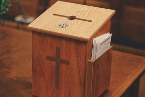 a wooden church offering box suggesting the ease of church embezzlement - U.S.S catholic