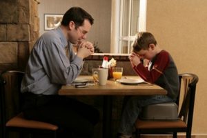 father-praying-with-son-at-dinner