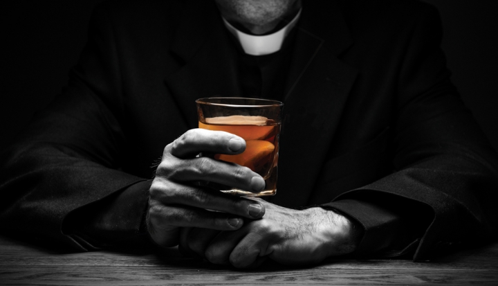 priest-holding-glass-of-whiskey
