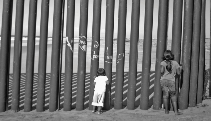 immigrant-children-looking-through-fence