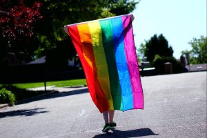 person-walking-holding-pride-flag