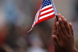childs-hands-holding-american-flag