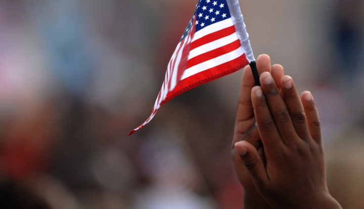 childs-hands-holding-american-flag