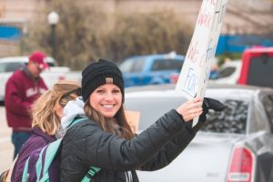 teacher-holding-sign-and-smiling