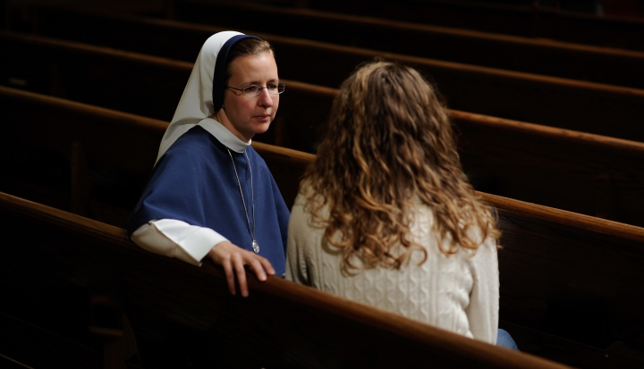 nun-speaking-with-layperson-in-pew