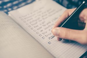 person-writing-checklist-in-journal