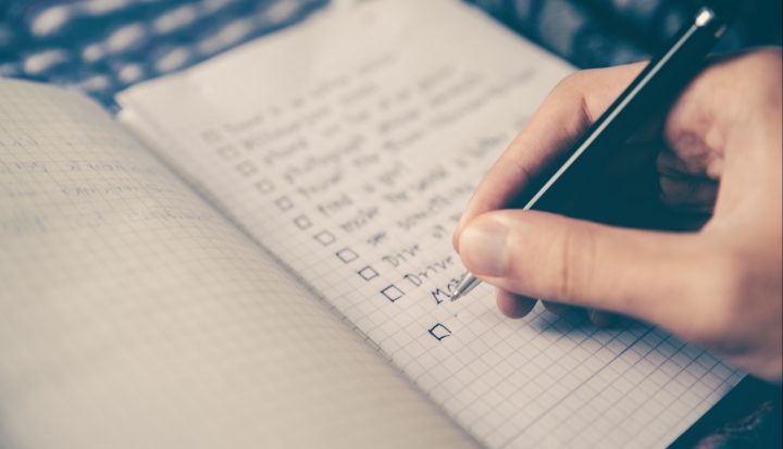 person-writing-checklist-in-journal