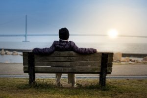 person-sitting-on-bench-by-water