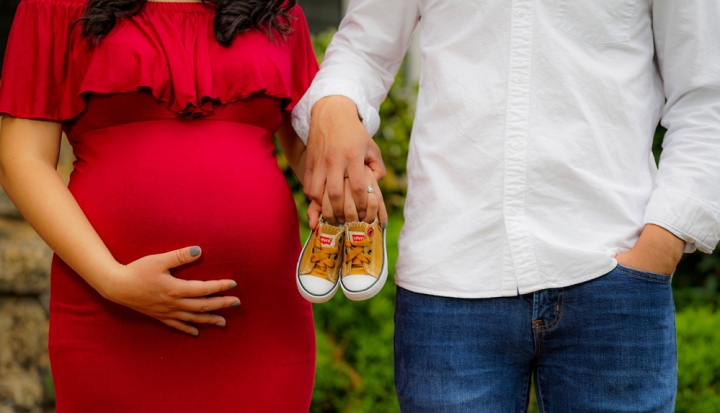 pregnant-couple-holding-baby-shoes
