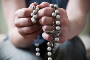 hands-holding-rosary-beads