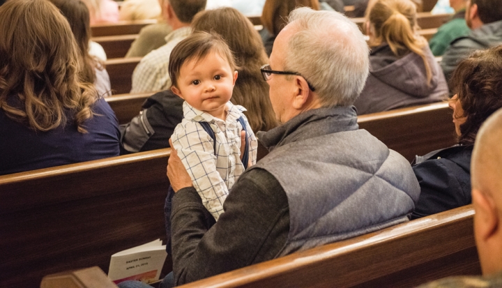 man-holding-baby-in-pew
