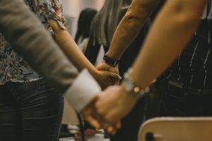 churchgoers-clasp-hands-in-prayer