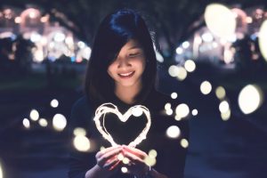 woman-holding-heart-made-of-light