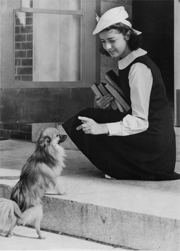 child-wearing-uniform-greets-small-dog