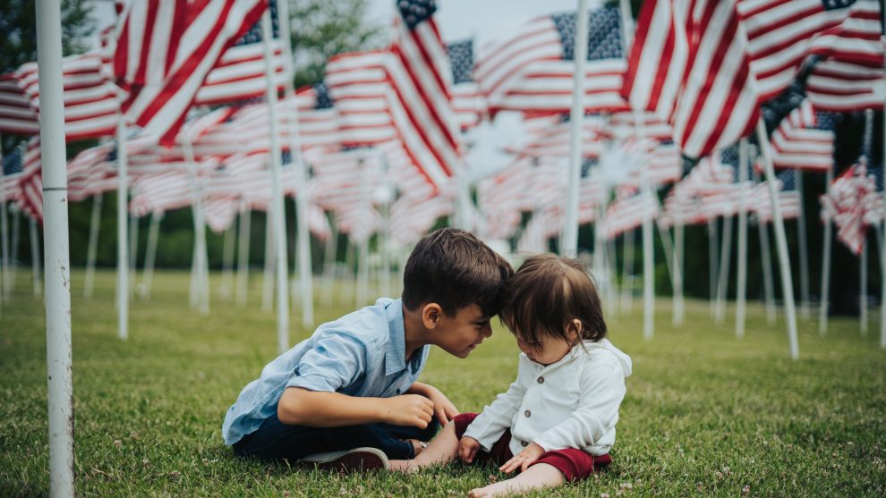 two-kids-on-grass-with-american-flags