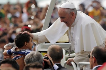 Pope-Fancis-blessing-a-child-in-a-crowd