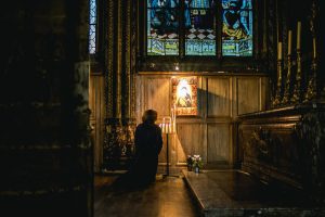 dark-church-woman-praying-in-front-of-tabernacle