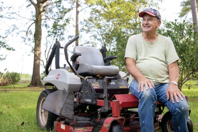 father-ron-foshage-sitting-on-a-riding-lawn-mower