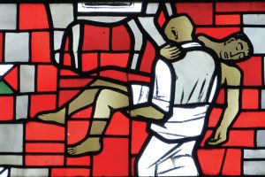 stained-glass-window-showing-one-man-carrying-another