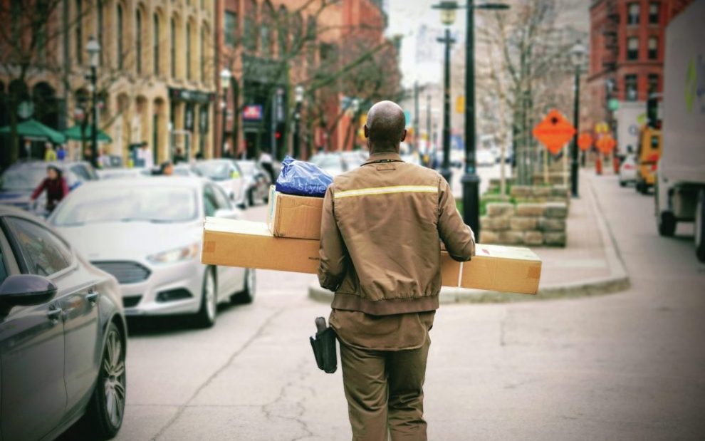 worker-carrying-packages-on-sidewalk