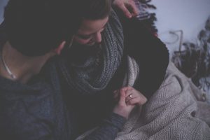 couple-embracing-under-grey-blanker