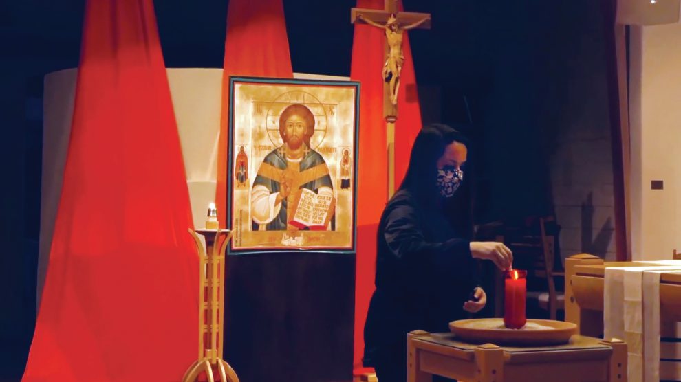 woman-lighting-a-candle-for-taize-prayer