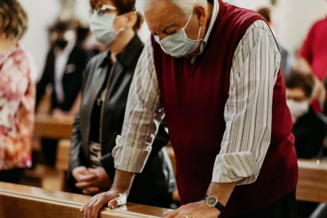 man-wearing-mask-praying-in-pew