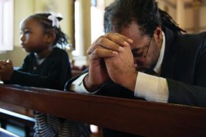 black-father-and-daughter-praying-in-pews