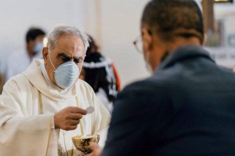 priest-in-mask-distributing-communion