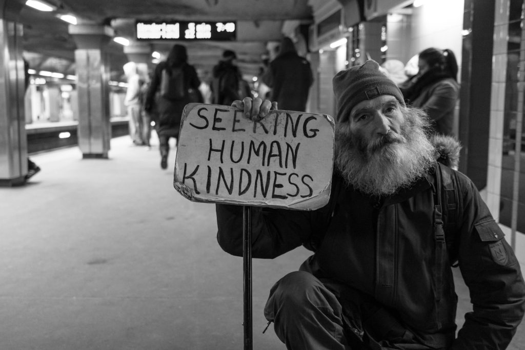 man-holding-sign-seeking-human-kindness