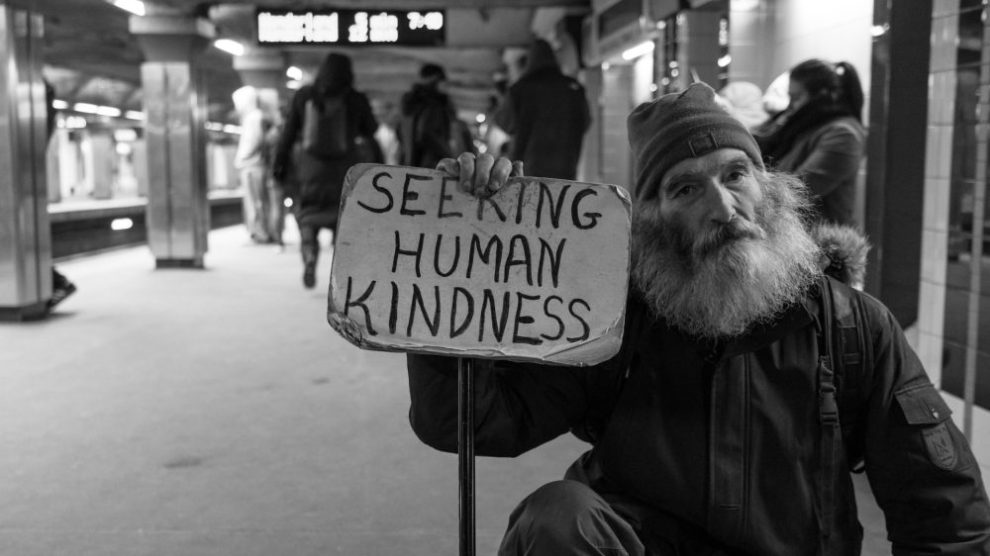 man-holding-sign-seeking-human-kindness