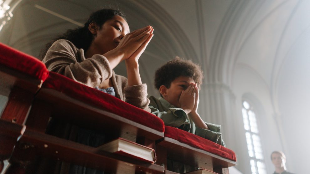mother-and-son-kneeling-and-praying-in-church