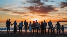 large-family-watching-sunset-at-beach