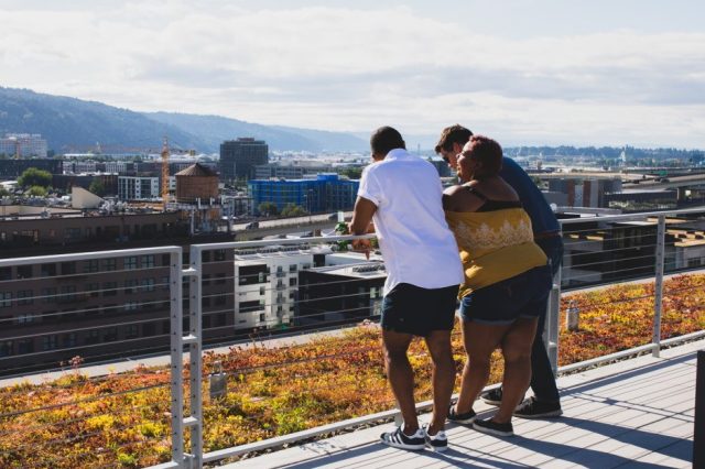 three-people-leaning-on-a-railing