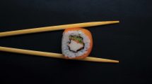 sushi-roll-held-by-chopsticks