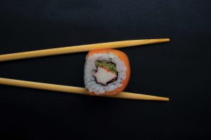 sushi-roll-held-by-chopsticks