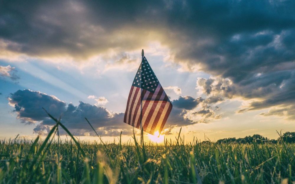 american-flag-in-field-at-sunset