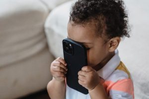 child-holding-smartphone-to-his-face