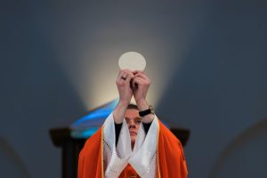 priest-holding-up-eucharist-during-mass