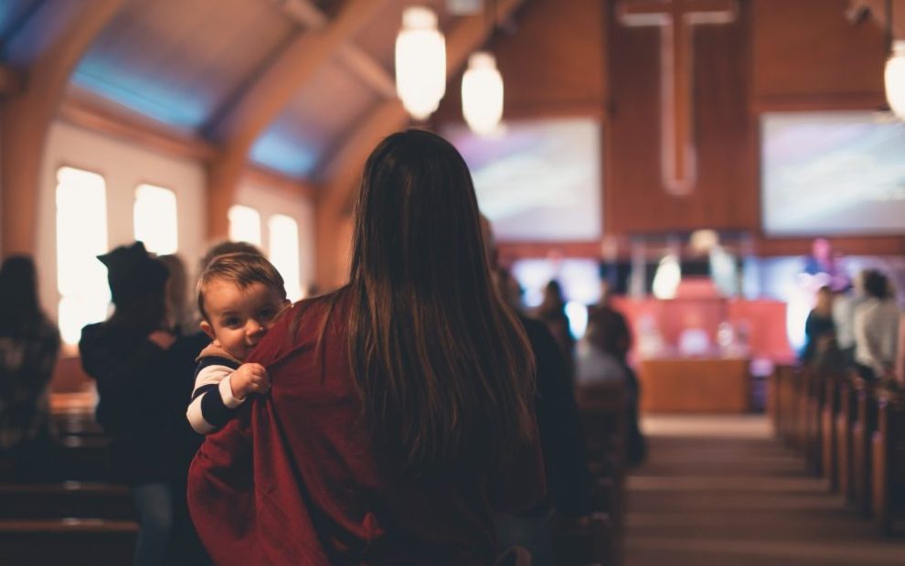 mother-holding-child-in-church-pew