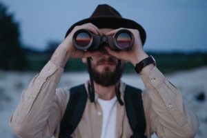 man-looking-through-binoculars