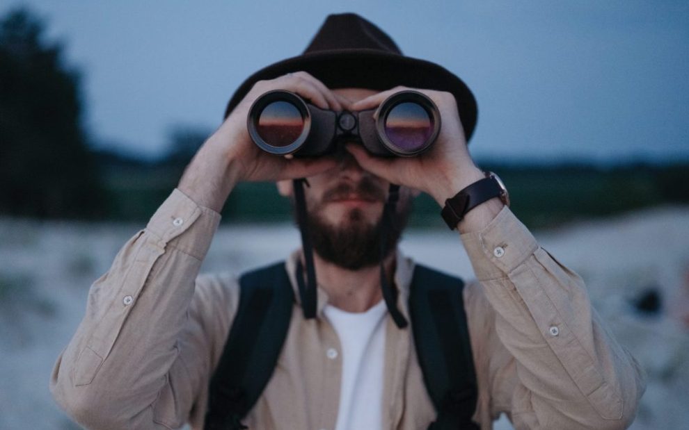 man-looking-through-binoculars