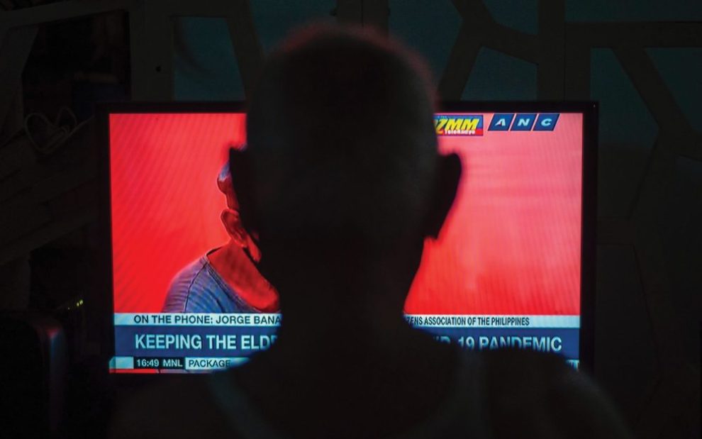 silhouette-of-person-watching-news-on-tv