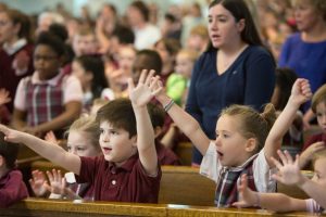children-in-catholic-school-uniforms-cheering