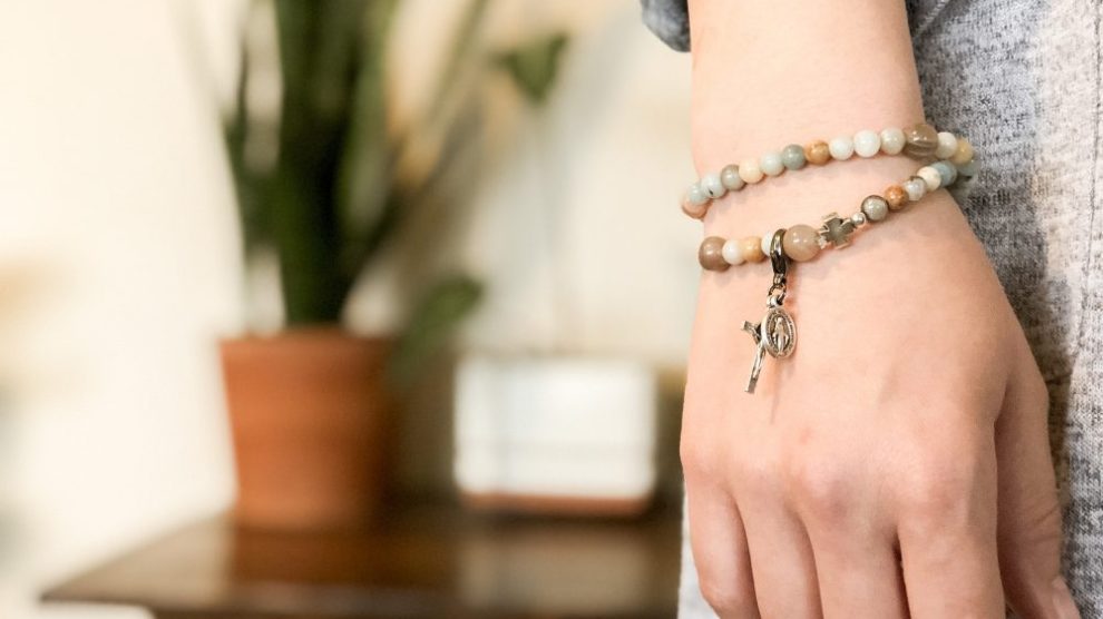 woman-wearing-bracelet-with-cross-and-miraculous-medal