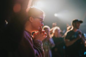 young-woman-praying-in-crowd