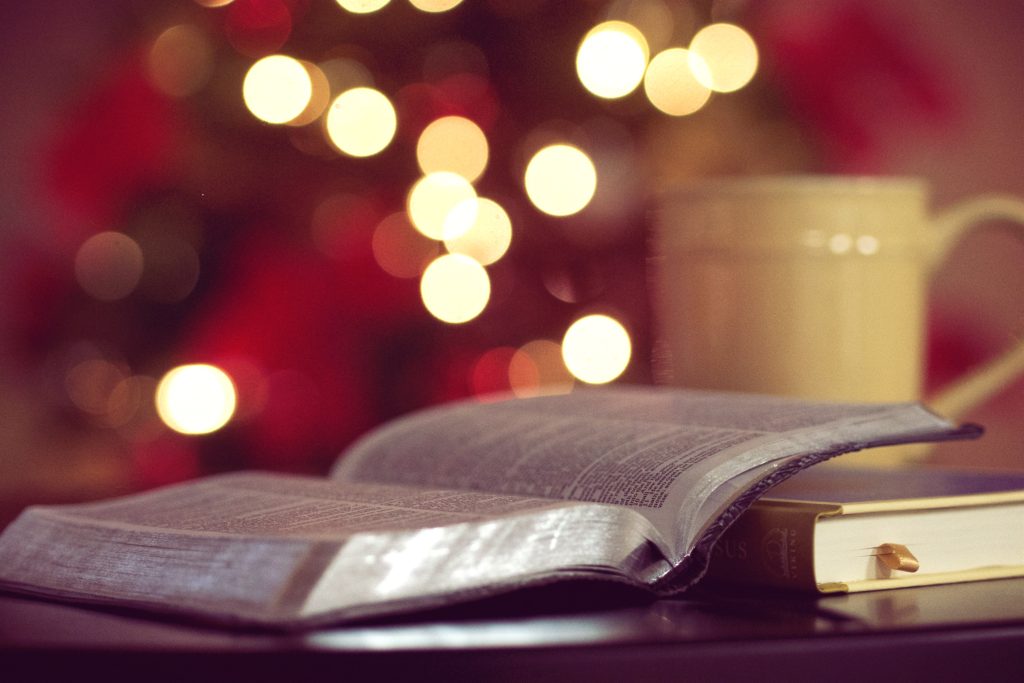 U.S. Catholic an open Bible and yellow mug sit in front of a Christmas tree