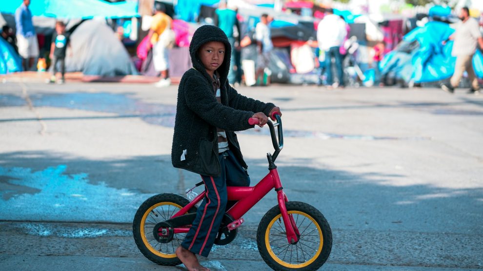 child-riding-bike-at-refugee-camp-on-united-states-border