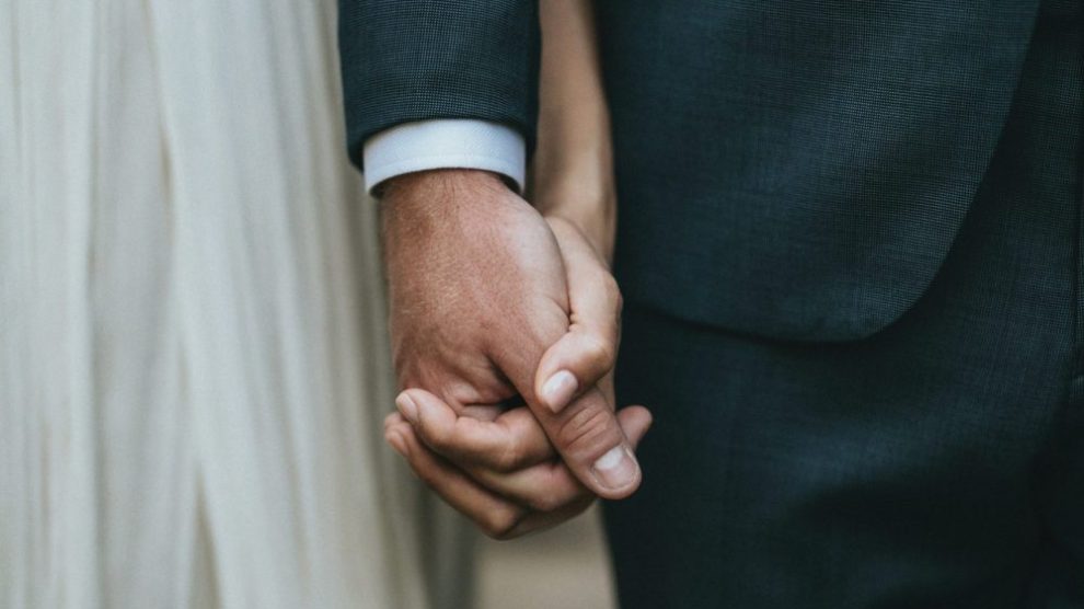 married-couple-at-wedding-holding-hands