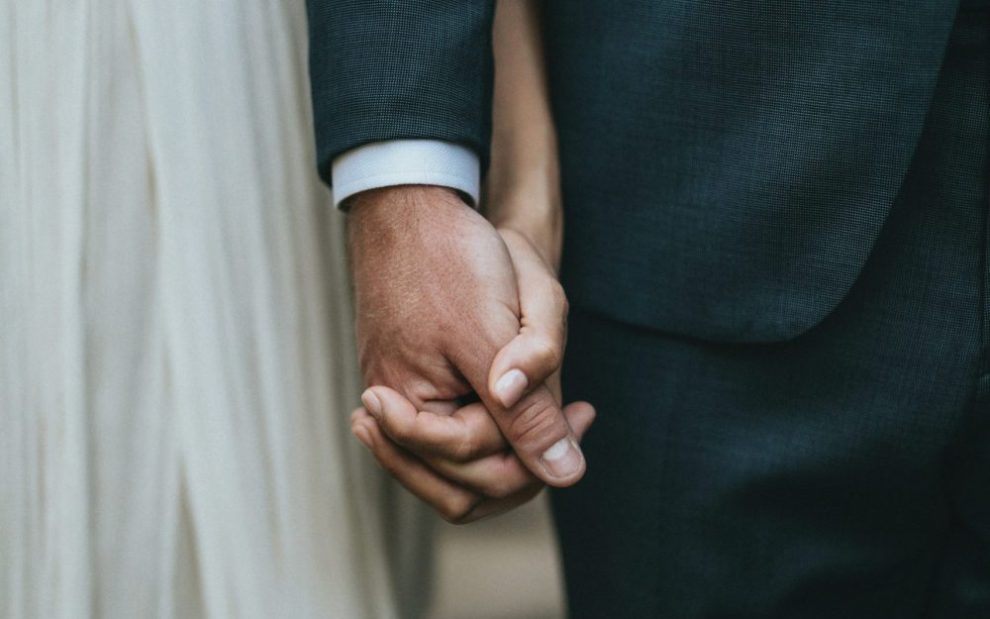 married-couple-at-wedding-holding-hands